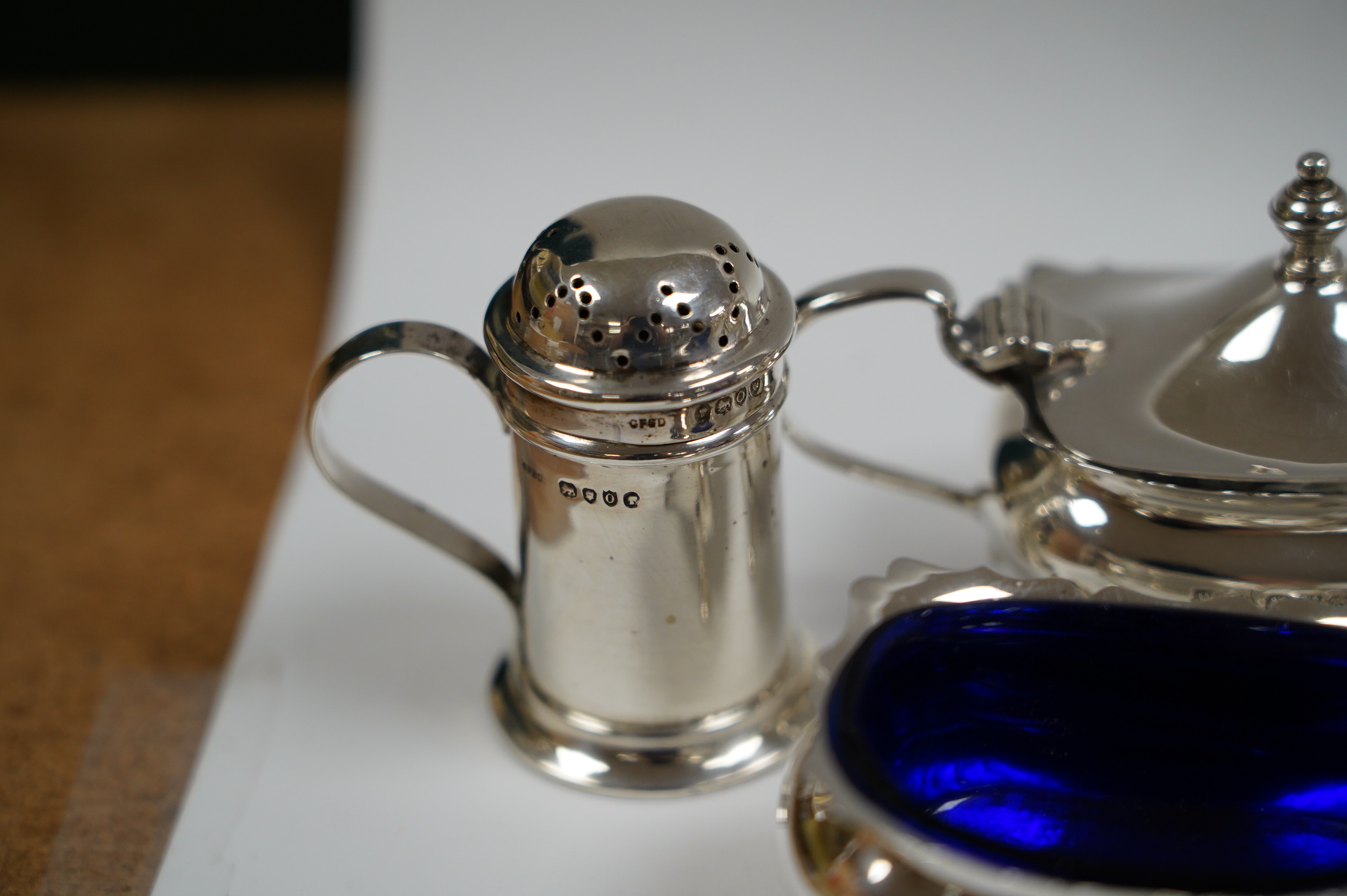 Six assorted silver condiments including a mounted ribbed glass pepper grinder and an Edwardian mounted glass cayenne pepper condiment, Condition - fair to good